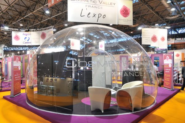 Une structure gonflable ronde et transparente en intérieur, dans un salon d'exposition